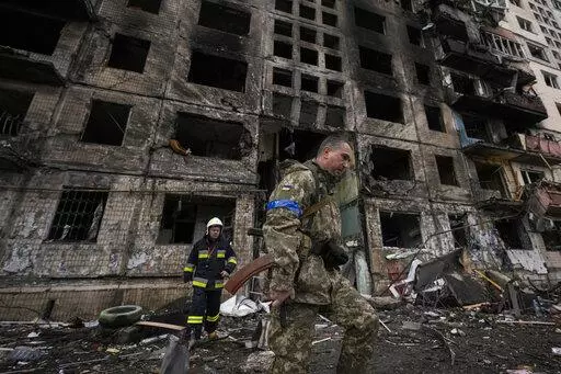 Ukrainian soldiers and firefighters search in a destroyed building after a bombing attack in Kyiv, Ukraine, Monday, March 14, 2022. (AP Photo/Vadim Ghirda, File)