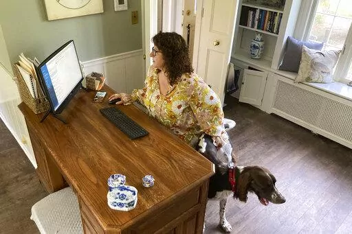 Sarah Motiff, from politically competitive Columbia, County, Wisconsin, works from home in Columbus, Wis., on Sept. 13, 2022. The 52-year-old city council woman and political independent says testimony that Republican Wisconsin Sen. Ron Johnson's office offered a fake slate of Wisconsin electors for the 2020 election "put a bad taste in my mouth." She is among independent voters nationally who have drifted toward supporting Democrats this fall. (AP Photo/Thomas Beaumont)