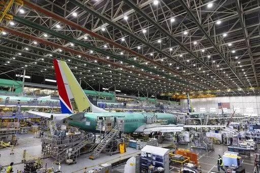 Boeing employees work on the 737 MAX on the final assembly line at Boeing's Renton plant, June 15, 2022 in Renton, Wash. The SEC announced Thursday, Sept. 22, 2022, that Boeing Co. will pay $200 million to settle allegations that the company and its former CEO misled investors about the safety of its 737 Max after two of the airliners crashed, killing 346 people. (Ellen M. Banner/The Seattle Times via AP, Pool, File)