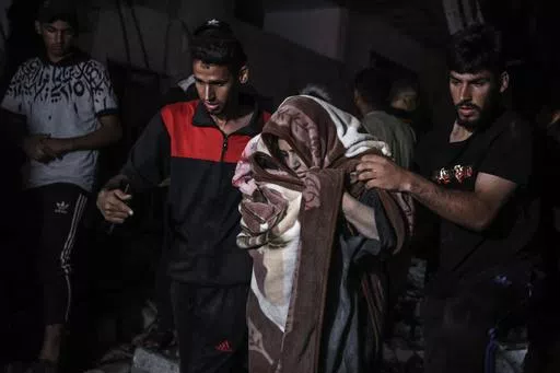Palestinians rescue a woman survived after the Israeli bombardment on a residential building of Abu Alenan family in Rafah, southern Gaza Strip, early Saturday, May 4, 2024. (AP Photo/Ismael Abu Dayyah)