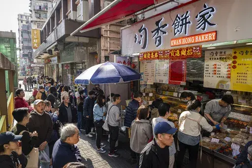 Customers wait in line outside Kwan Hong Bakery in Hong Kong, Saturday, Jan. 18, 2025. (AP Photo/Chan Long Hei)