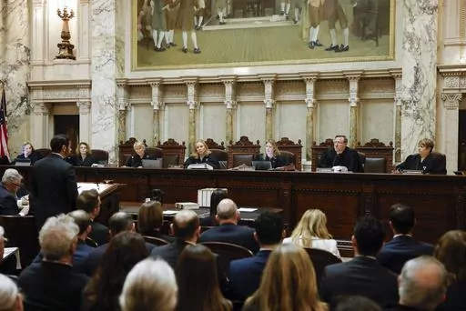 The Wisconsin Supreme Court listens to arguments from Wisconsin Assistant Attorney General Anthony D. Russomanno, representing Gov. Tony Evers, during a redistricting hearing at the state Capitol, Nov. 21, 2023, in Madison, Wis. The liberal-controlled Wisconsin Supreme Court overturned Republican-drawn legislative maps on Friday, Dec. 22, and ordered that new district boundary lines be drawn as Democrats had urged in a redistricting case they hope will weaken GOP majorities. (Ruthie Hauge/The Ca