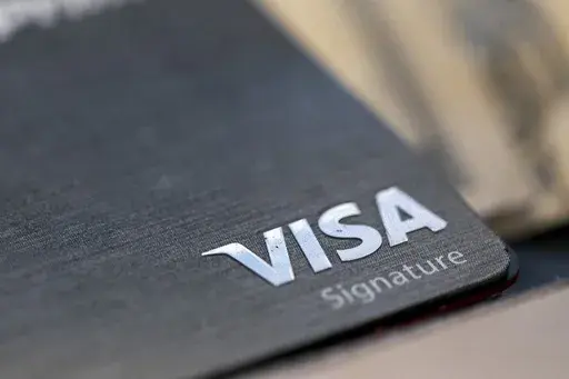 FILE- This photo shows a Visa logo on a credit card in New Orleans, Aug. 11, 2019. (AP Photo/Jenny Kane, File)