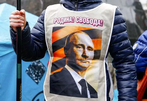 A pro-Russia demonstrator wears a vest bearing a depiction of Russian President Vladimir Putin and the words, "Motherland! Freedom!" during a rally in Donetsk, Ukraine, Sunday, March 16, 2014. Pro-Russia demonstrators in the eastern city of Donetsk called for a referendum similar to the one in Crimea. (AP Photo/Andrey Basevich, File)