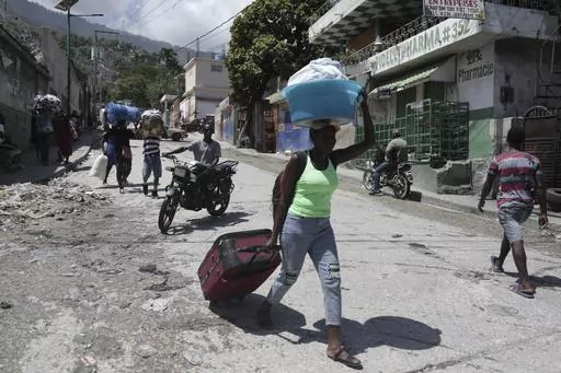 Residents flee their homes to escape clashes between armed gangs in the Carrefour-Feuilles district of Port-au-Prince, Haiti, Aug. 25, 2023. The United Nations Security Council approved on Oct. 2 the deployment of an international armed force to Haiti. (AP Photo/Odelyn Joseph, File)