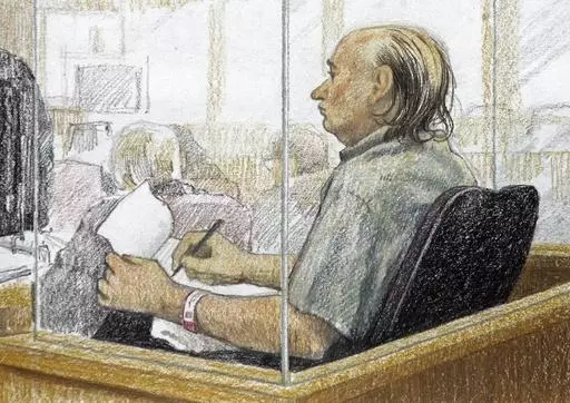 This artist's sketch shows accused serial killer Robert Pickton taking notes during the second day of his trial in B.C. Supreme Court in New Westminster, British Columbia, Jan. 31, 2006. Convicted Canadian serial killer Pickton has been hospitalized and is in a life-threatening condition after an assault at a Quebec prison, authorities said Tuesday, May 21, 2024. (Jane Wolsack/The Canadian Press via AP)