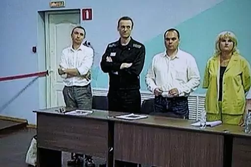 FILE Russian opposition leader Alexei Navalny, 2nd left, and his lawyers Alexander Fedulov, left, Olga Mikhailova, right, and Vadim Kobzev, second right, are seen on a TV screen standing among his lawyers, as he appears in a video link provided by the Russian Federal Penitentiary Service, during a hearing in the colony, in Melekhovo, Vladimir region, about 260 kilometers (163 miles) northeast of Moscow, Russia, on Friday, Aug. 4, 2023. Russian authorities on Friday, Oct. 13, 2023 searched the ho