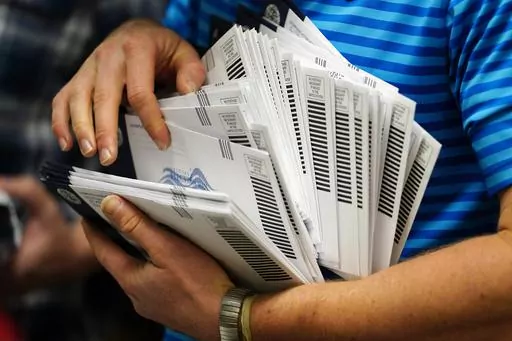 Kyle Hallman, with Chester County Voter Services, organizes mail-in ballots to be sorted for the 2020 General Election Oct. 23, 2020, in West Chester, Pa. Republicans are challenging extended mail ballot deadlines in at least two states in a move that could have severe implications for mail voting nationwide ahead of this year's presidential election. A lawsuit filed last week in Mississippi follows a similar one last year in North Dakota, both brought in heavily Republican states before conserv