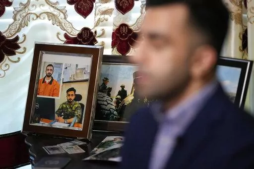 Photographs of Abdul Wasi Safi sit on a table as his brother, Sami-ullah Safi talks about his brother's journey to the U.S. during an interview Wednesday, Jan. 18, 2023, in Houston. Abdul Wasi Safi was an intelligence officer with the Afghan National Security Forces, providing U.S. armed forces with information for operations against terrorists, said Sami-ulllah Safi. Wasi, as he is called by his family, was arrested after crossing the U.S.-Mexico border near Eagle Pass, Texas in September 2022,