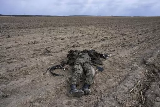 A Russian soldier killed during combats against Ukrainian army lies on a corn field in Sytnyaky, on the outskirts of Kyiv, Ukraine, Sunday, March 27, 2022. Nearly 50,000 Russian soldiers have died in the war in Ukraine, according to a new statistical analysis. (AP Photo/Rodrigo Abd, File)