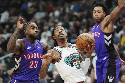 Memphis Grizzlies' Ja Morant (12) drives between Toronto Raptors' Jamal Shead (23) and Toronto Raptors' Scottie Barnes, right during first half NBA basketball action in Toronto on Wednesday, Feb. 5, 2025. (Frank Gunn/The Canadian Press via AP)