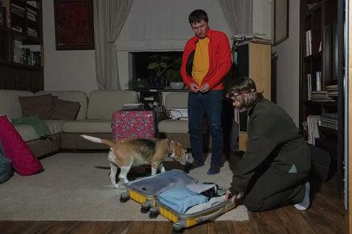 Yaroslav Vedmid, centre and his wife Olena check their luggage in a village during a blackout on the outskirts of Kyiv, Ukraine, Thursday, Oct. 27, 2022. Russian attacks on Ukraine's energy infrastructure have triggered power cuts across the country since early October. Rolling blackouts are increasing across Ukraine as the government rushes to stabilise the energy grid and repair the system ahead of winter. (AP Photo/Andrew Kravchenko)