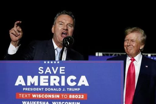 Wisconsin Republican gubernatorial candidate Tim Michels, left, speaks as former President Donald Trump, right, listens at a rally Aug. 5, 2022, in Waukesha, Wis. Michels casts himself as an outsider, although he previously lost a campaign to oust then-U.S. Sen. Russ Feingold in 2004 and has long been a prominent GOP donor. (AP Photo/Morry Gash, File)