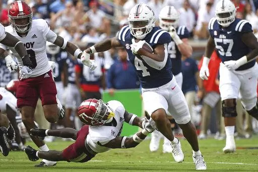 Mississippi running back Quinshon Judkins (4) runs the ball past Troy safety Craig Slocum Jr. (4) during the first half an NCAA college football game in Oxford, Miss., Saturday, Sept. 3, 2022. (AP Photo/Thomas Graning)